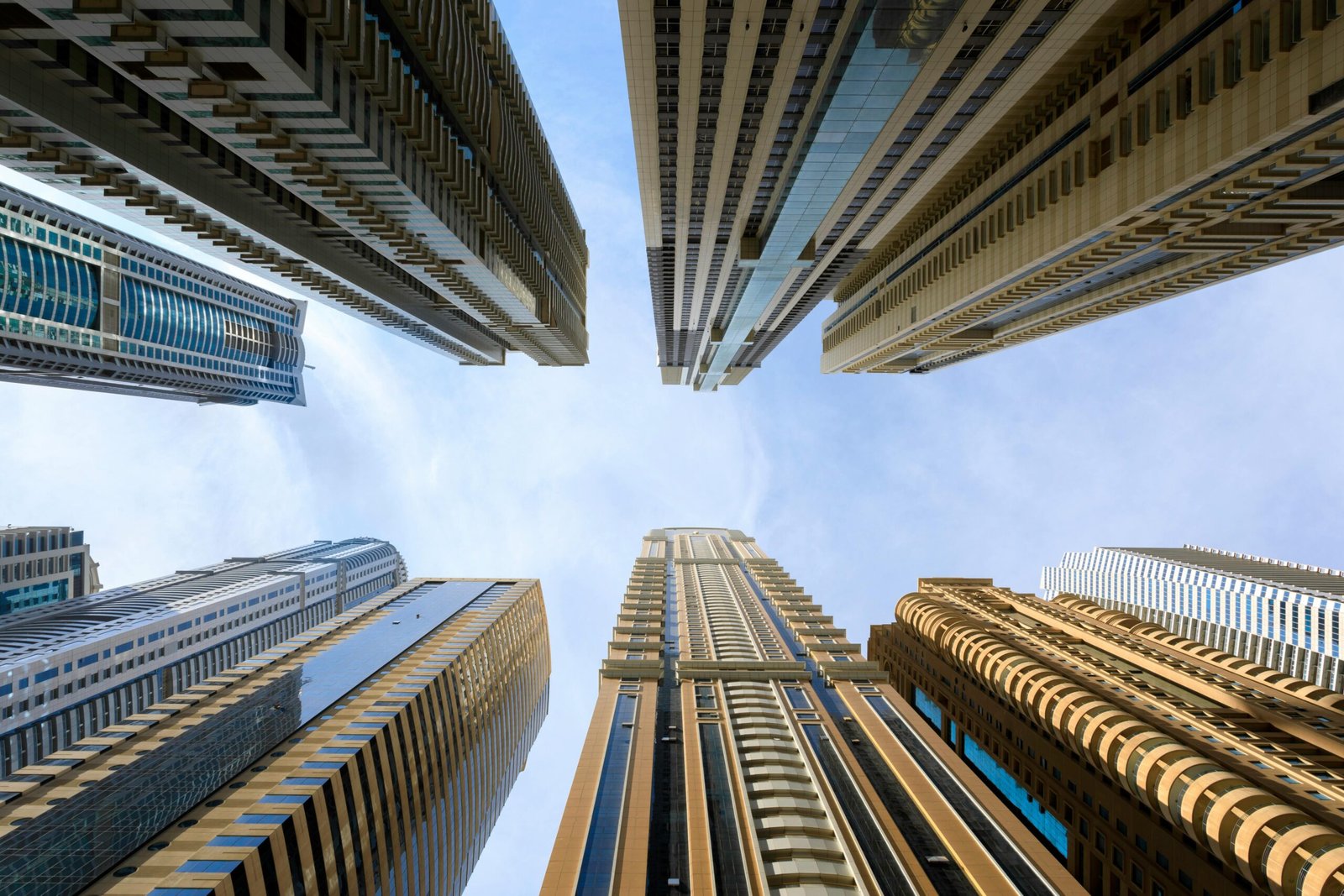 Low angle view of modern skyscrapers against a bright sky, showcasing urban architecture.